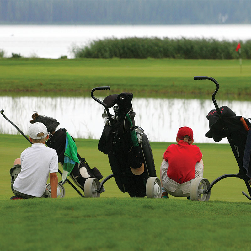 kids sitting on a golf course