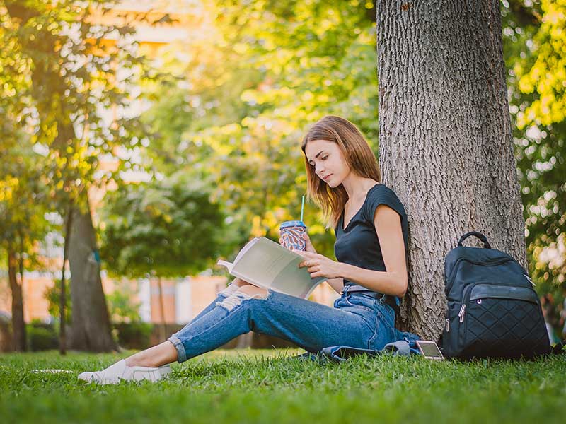 Municipalities and Campus- girl reading a book under a tree