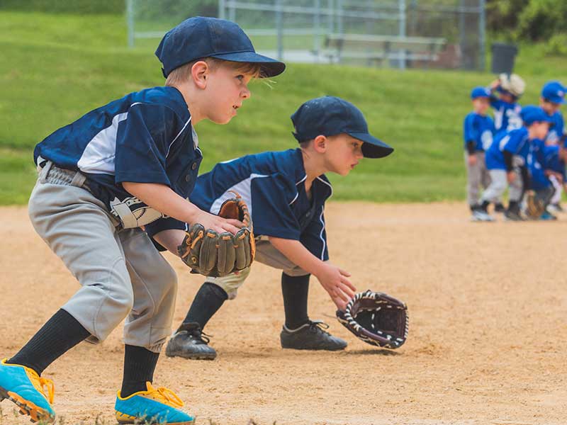 kids playing baseball on little league sports fields