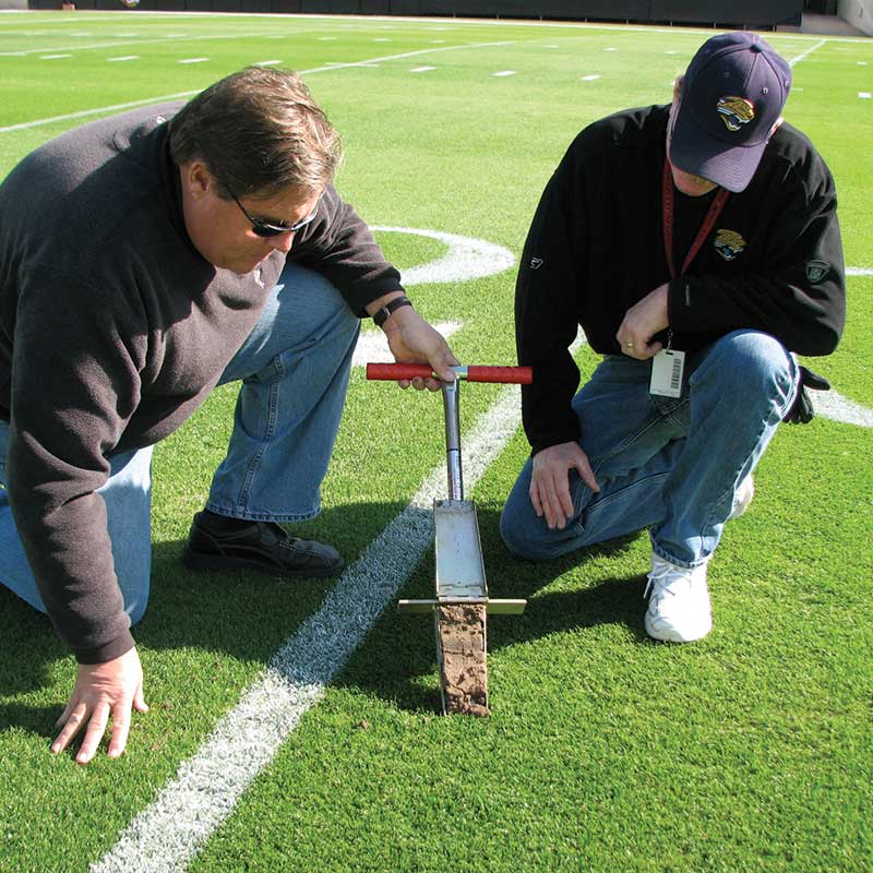 professionals taking a soil sample on NFL sports fields